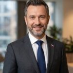 Портрет уверенного российского бизнесмена с дружелюбным взглядом на размытом нейтральном фоне в студии